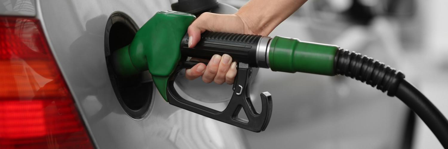 a person holding a gas pump in their car
